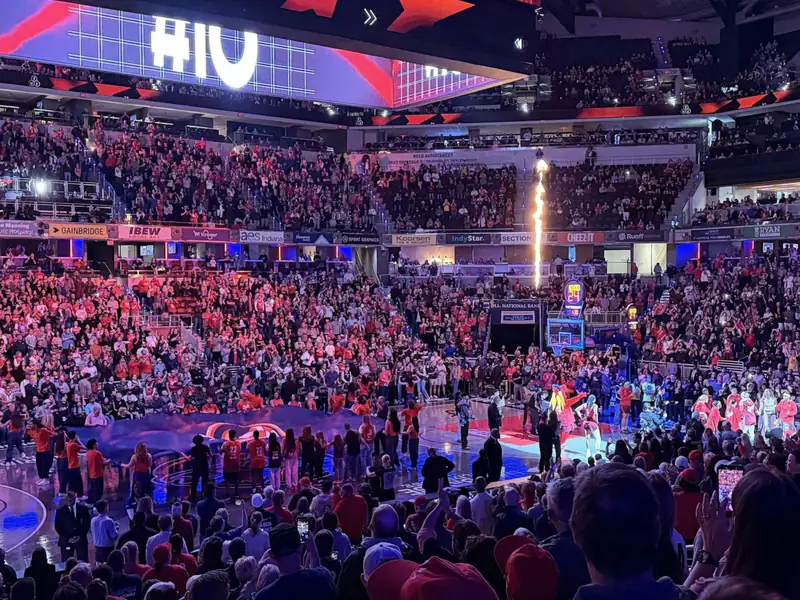 A packed Gainbridge Fieldhouse in Indianapolis under red and purple lights during pregame introductions.